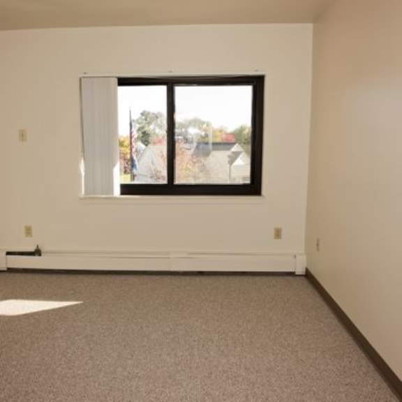 a room with a carpeted floor and a window.