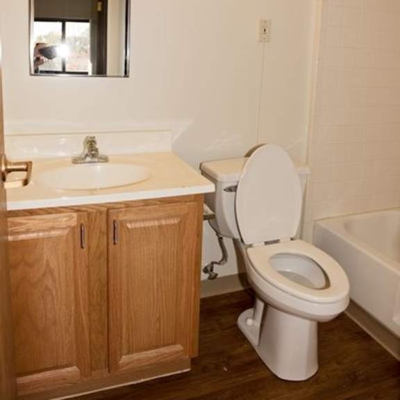 a white toilet sits in a bathroom next to a sink and a mirror.