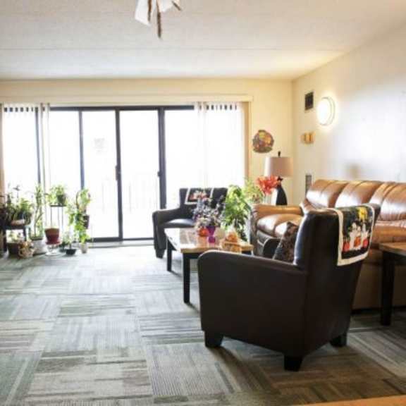 a living room with a brown couch and a wooden table.