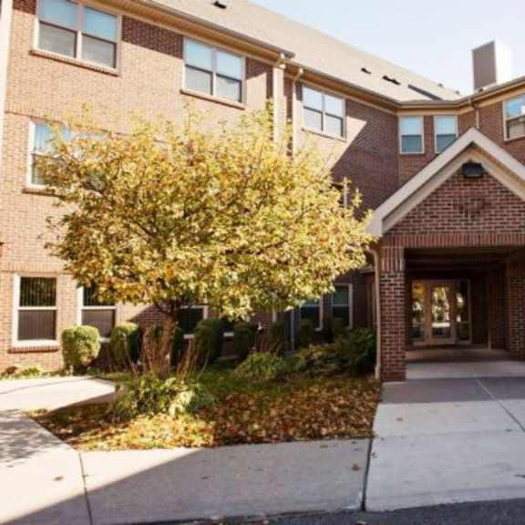 a brick building with a covered walkway entrance.
