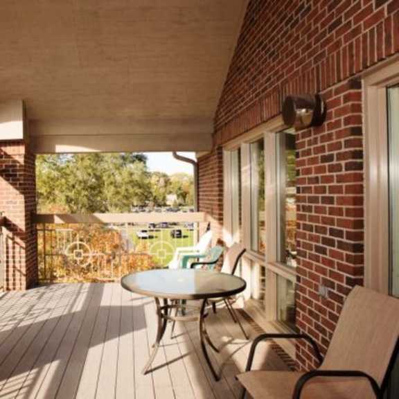 a balcony with a table and chairs is shown.