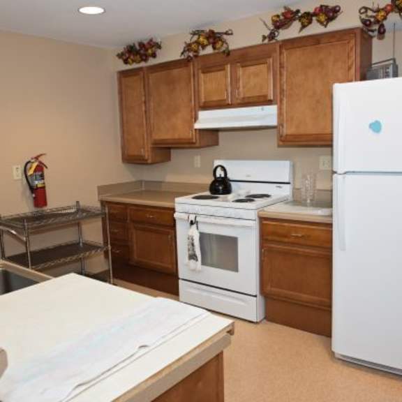 a kitchen with white appliances and wooden cabinets.