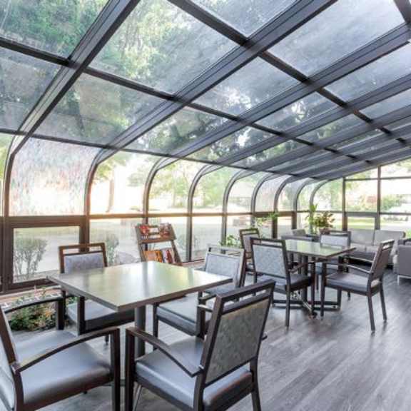 a glass-roofed room with a table and chairs.