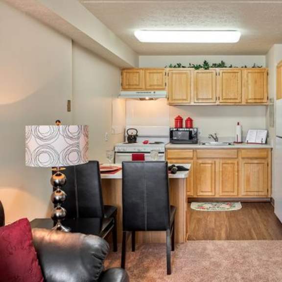 a kitchen with a white fridge and a table with chairs.