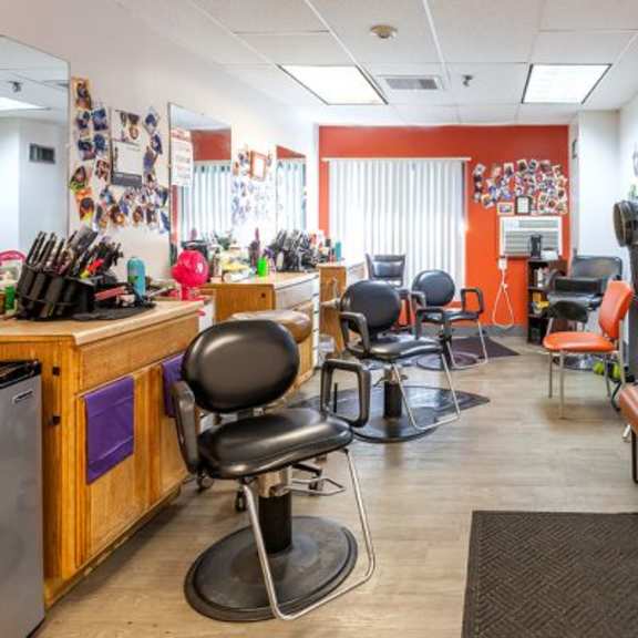 a room with a long table and chairs, a bench, and pictures on the wall.