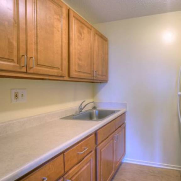 a kitchen with a white stove and wooden cabinets.