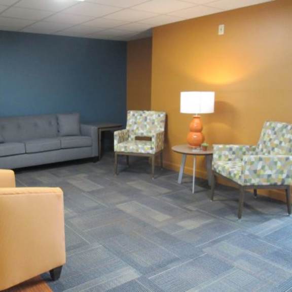 a living room with a grey sofa, two chairs and a yellow armchair.