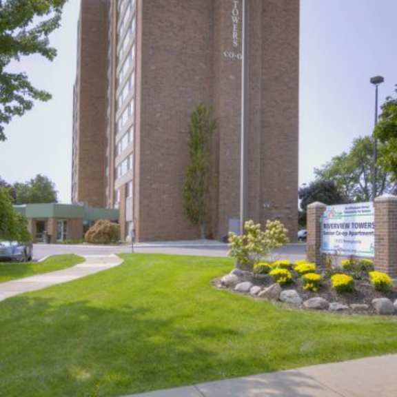 a tall brick building with a sign in front that says "benedictine towers".