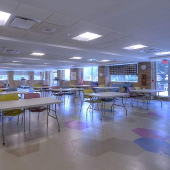 a room with tables and chairs and an american flag.