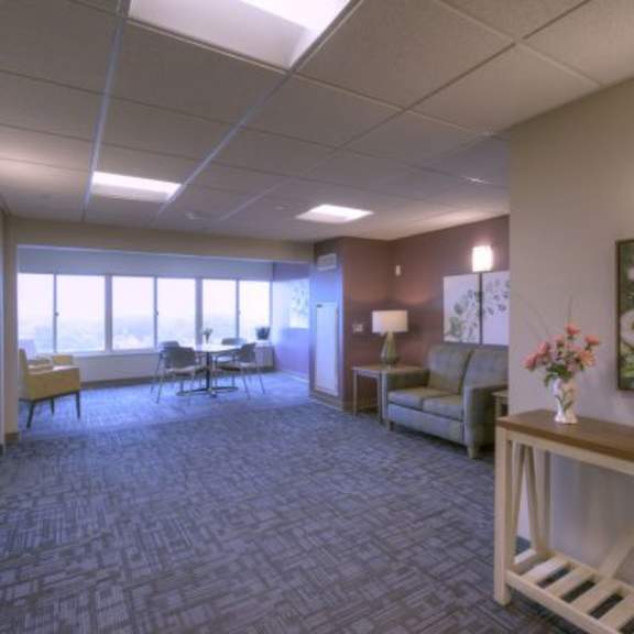 a room with a grey carpet and a wooden bench.