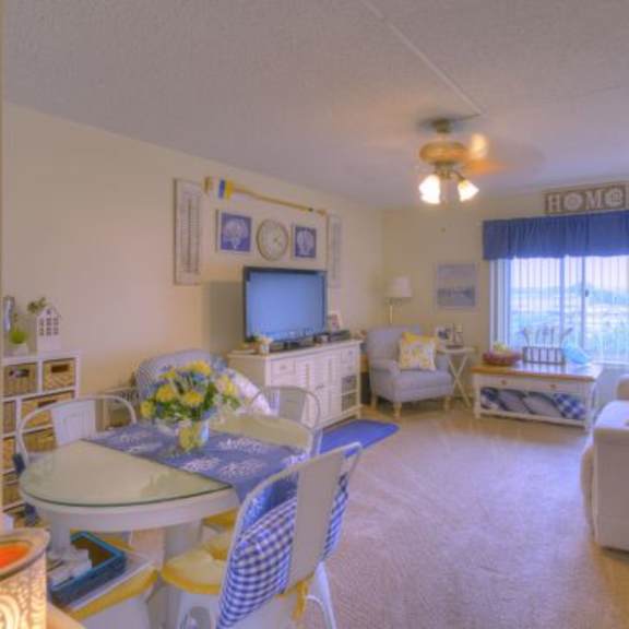 a sunny room with a table and chairs.