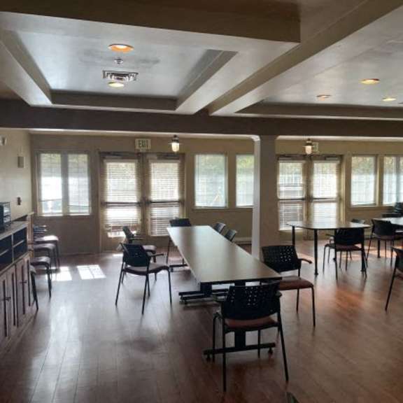 a large room with tables and chairs and a television.