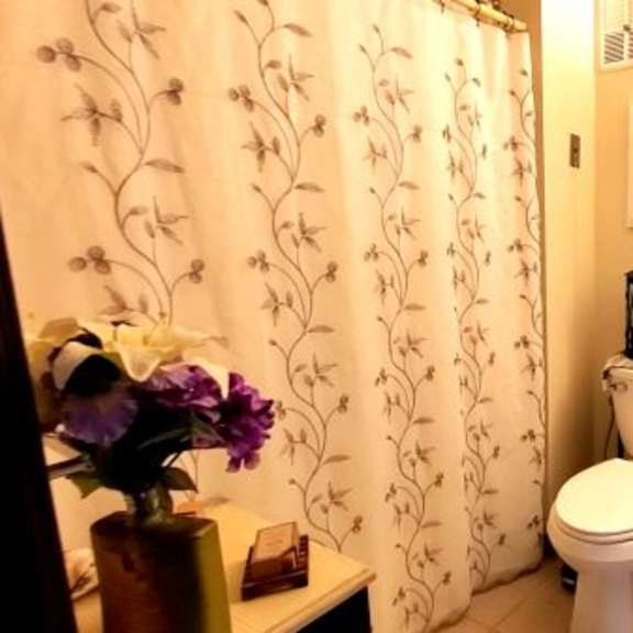 a bathroom with a toilet, sink, and shower curtain.