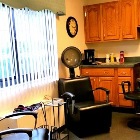 a hair salon with black chairs and a mirror.