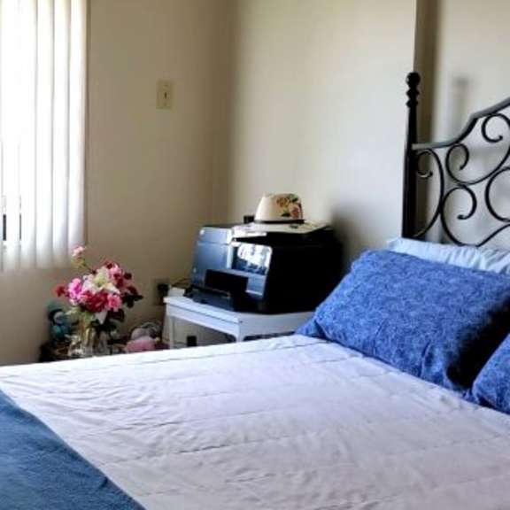 a bedroom with a bed, a bicycle, and a window with blinds.