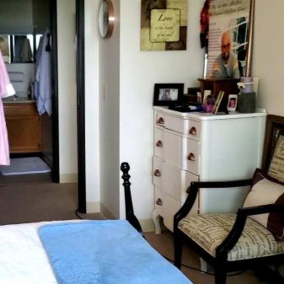 a bedroom with a bed, chair, and closet.