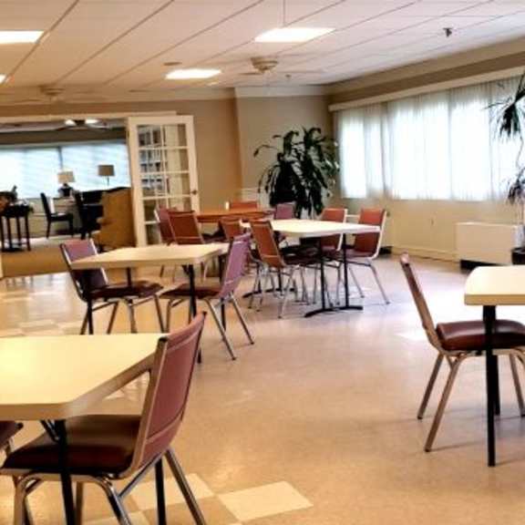 a room with tables and chairs is empty.