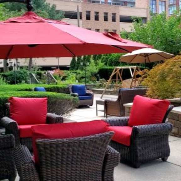 a patio with red cushions and a red umbrella.