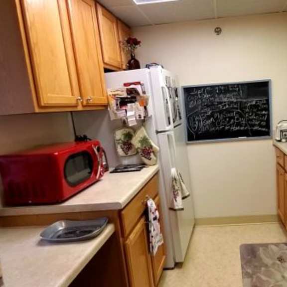 a kitchen with wooden cabinets and a chalkboard on the wall.