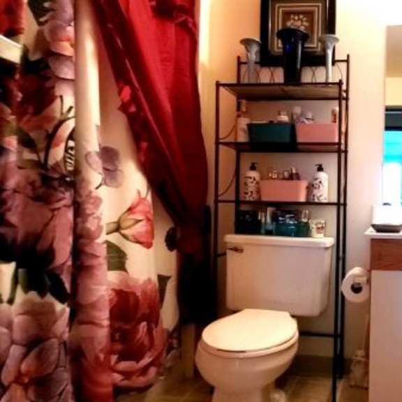 a bathroom with a toilet, sink, and a mirror.