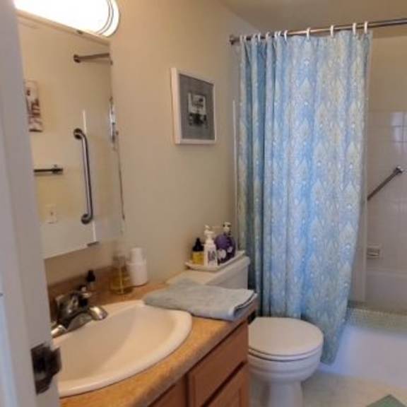 a bathroom with a toilet, sink, and shower.