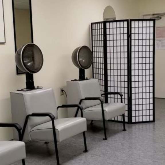a room with chairs and a white door with a black gate.