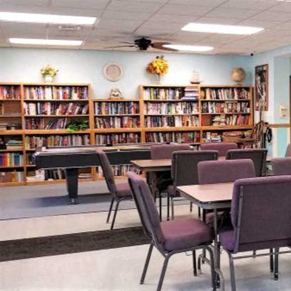 a library with purple chairs and tables.