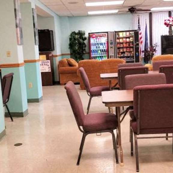 a room with tables and chairs and a counter.