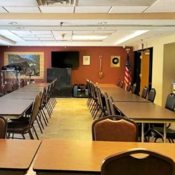 a large room with tables and chairs and a flag on the wall.