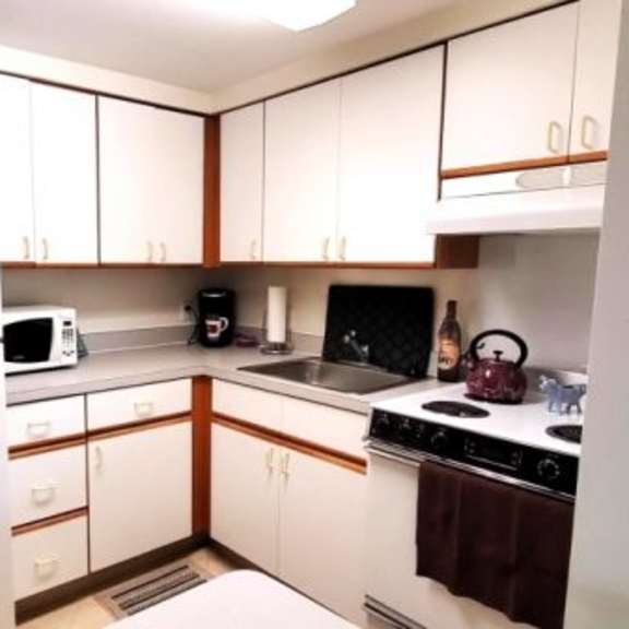 a kitchen with white appliances and wooden cabinets.