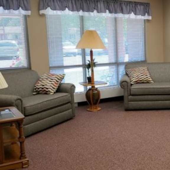 a living room with grey couches and a lamp.