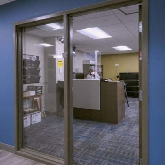 a glass door with a sign on it is open.