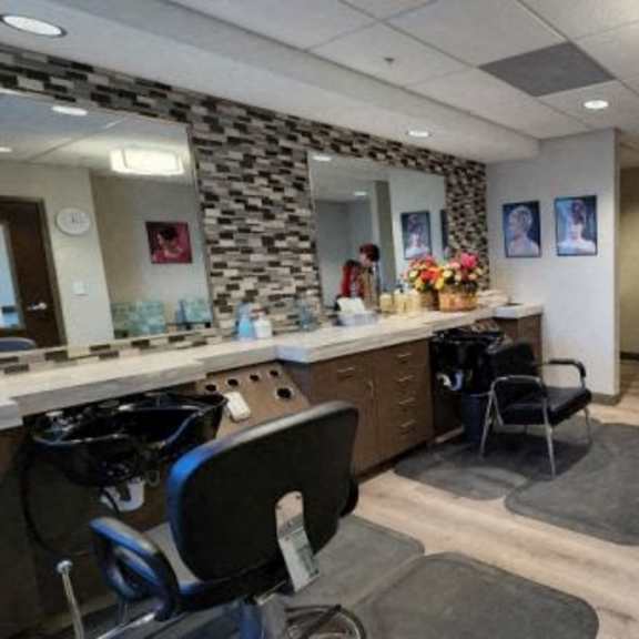 a salon with chairs and a counter with a mirror.