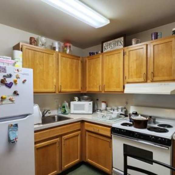a kitchen with wooden cabinets and a white fridge.