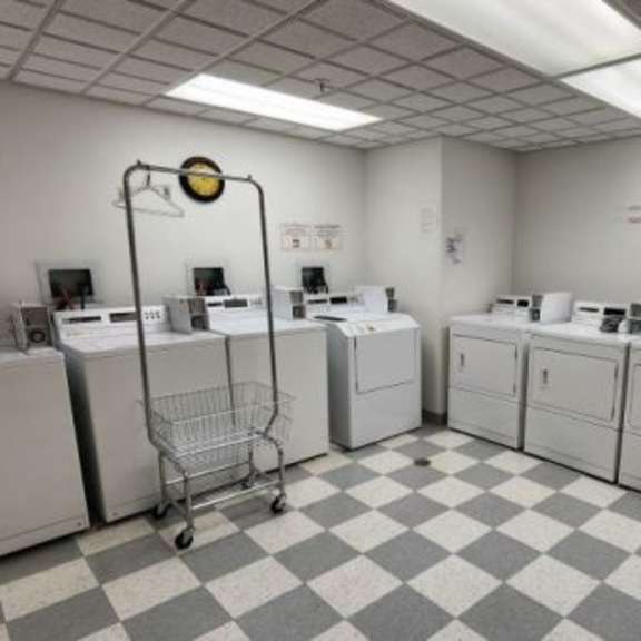 a room with a checkered floor and several washing machines.