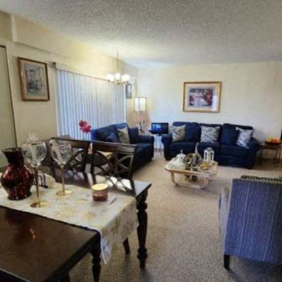 a living room with a couch, chairs, and a dining table.
