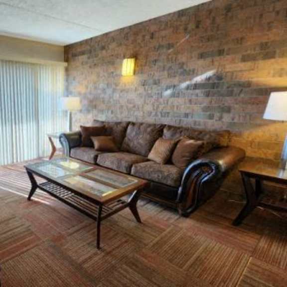 a living room with a brick wall and a couch.