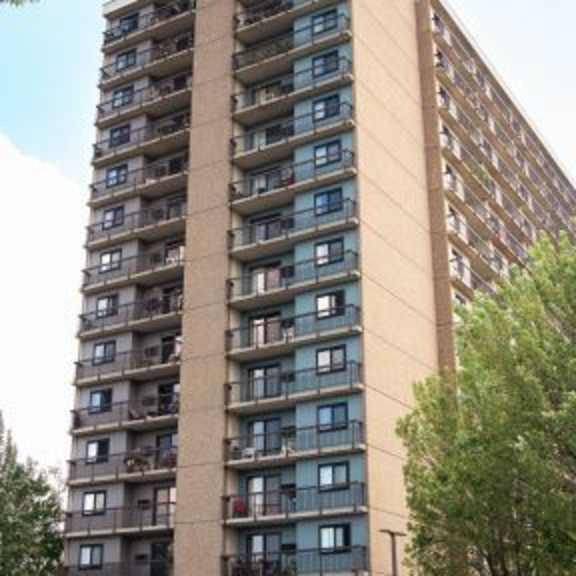a tall apartment building with balconies on the upper floors.