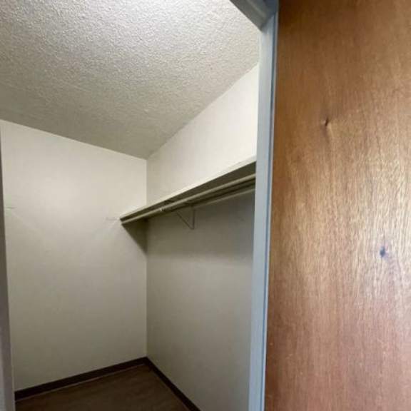 a small closet with a shelf and a door.