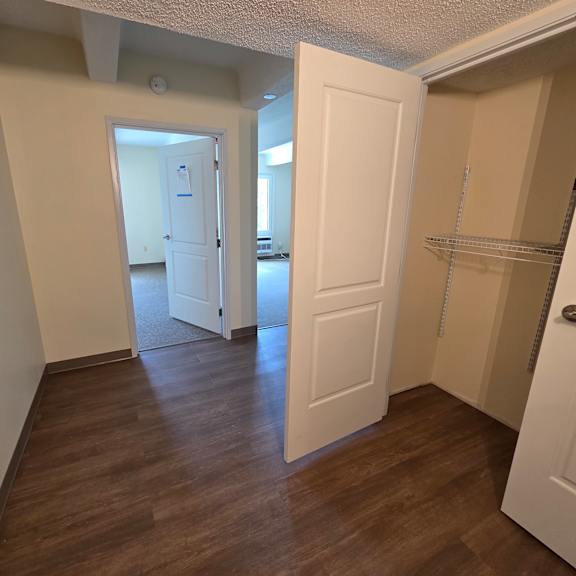 a room with a white door and a wooden floor.