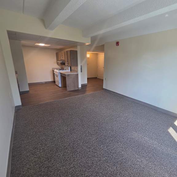 a room with a grey carpet and white walls.