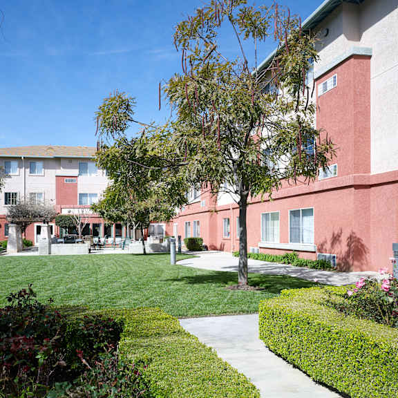 a red building with a green lawn in front.