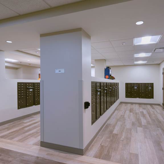 a hallway with a grey door and a red light on the ceiling.