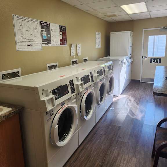 a row of washing machines are lined up in a laundromat.