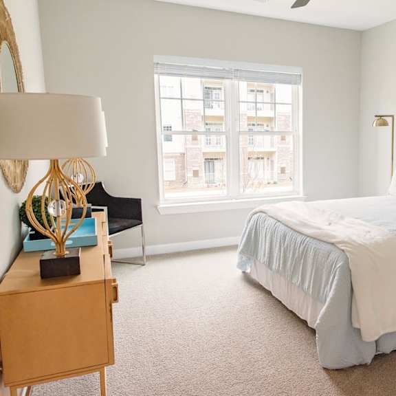 featured bedroom at reserve at glen laurel with lots of natural light, a bed, and dresser,