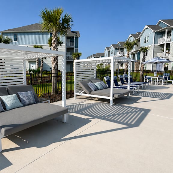 a white wooden patio furniture set with cushions and pillows.