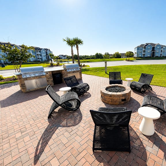 a sunny day at a brick patio with black chairs and tables.