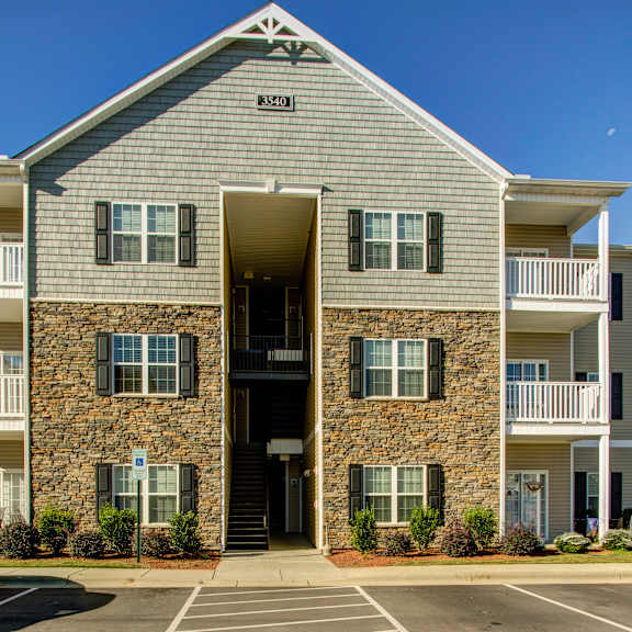 the front of apartment building number 3340 with a parking lot in front.