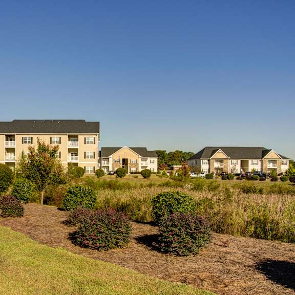 apartment complex with green grass in front.