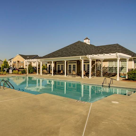 a large swimming pool in front of a house.